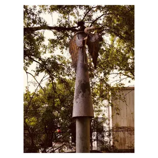 a statue of an angel hanging from a tree