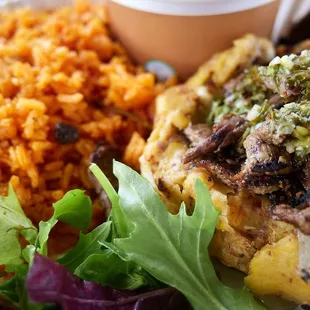 Mofongo de carna (mashed fried plantains w/ garlic and bacon topped with flank steak, gandule rice and habichuelas)