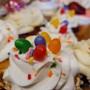 cupcakes with white frosting and colorful candies
