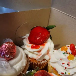 a box of cupcakes with a strawberry on top