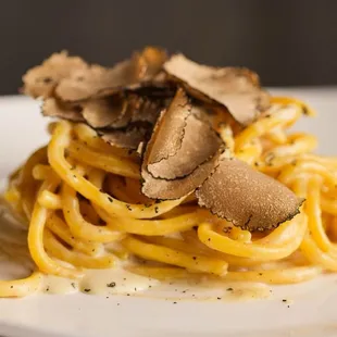 a plate of pasta with truffle on top