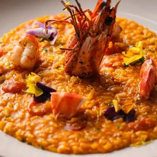 a plate of risotto with shrimp and vegetables