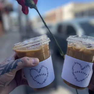 two people holding cups of coffee