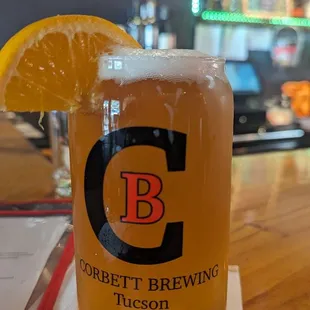 a pint of beer with a slice of orange