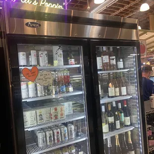 Boozy seltzers and wines behind cashier.