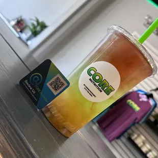 a cold drink in a plastic cup with a green straw