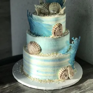 a three tiered cake decorated with seashells