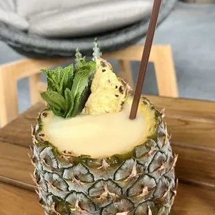 a pineapple drink with a straw