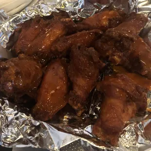 ows a plate of chicken wings covered in bbq sauce