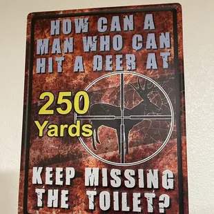 a sign that says, how can a man who can hit a deer at 250 yards keep missing the toilets?