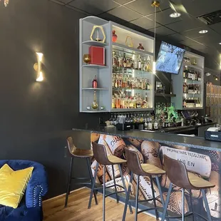 a bar with stools and a television