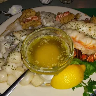a plate of lobster, scallops, and lemon