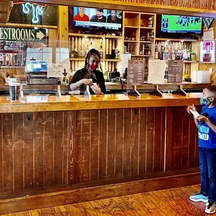 ows a young boy standing at the bar