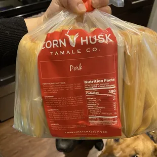 a person holding a bag of corn husk