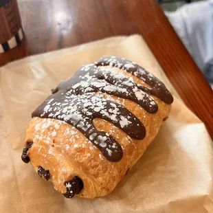 a pastry with chocolate icing and powdered sugar