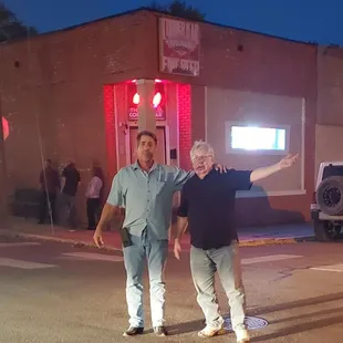 two men standing in the middle of the street
