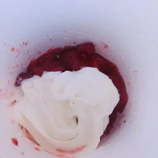a bowl of whipped cream and raspberry sauce