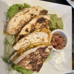 Chicken quesadillas. Very yummy. A side of salsa, guacamole, and sour cream.