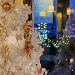 a white christmas tree with gold ornaments