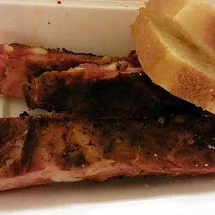 a plate of ribs and a side of bread