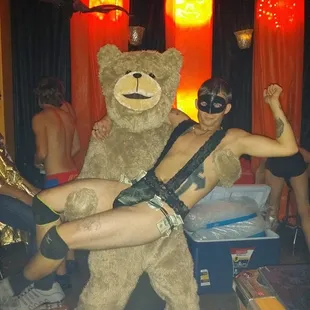 a man in a bear costume being carried by a woman