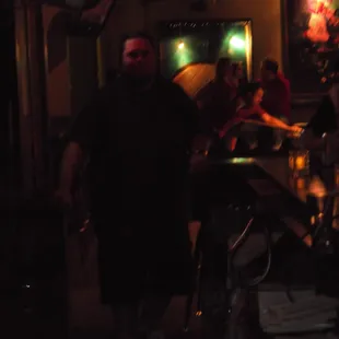 a man standing in a dimly lit bar