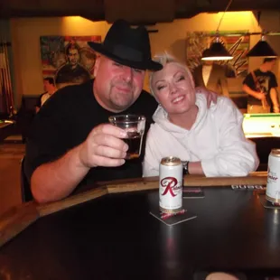 a man and a woman sitting at a pool table