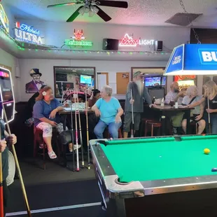 a group of people playing a game of pool