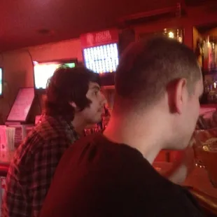 two men sitting at a bar