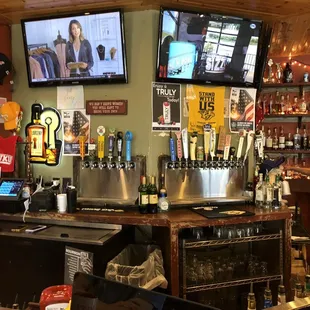 a bar with a television and beer taps