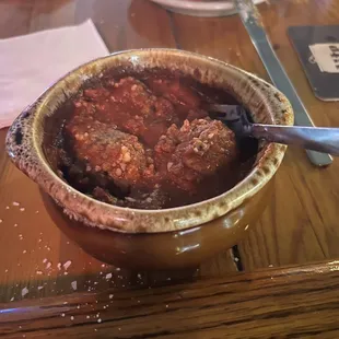 a bowl of chili and bread on a table