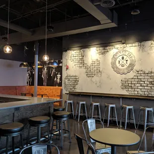 a bar with stools and a clock on the wall