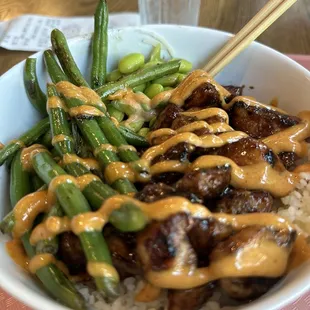 a bowl of food with chopsticks