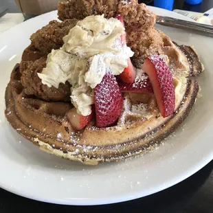 a waffle topped with whipped cream and strawberries