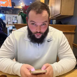 a man sitting at a table looking at his cell phone