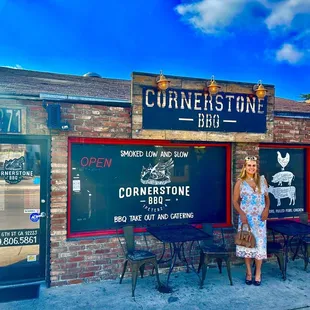 a woman standing in front of a brick building