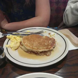 a plate of pancakes with bacon and eggs