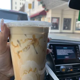 a hand holding a cup of iced coffee