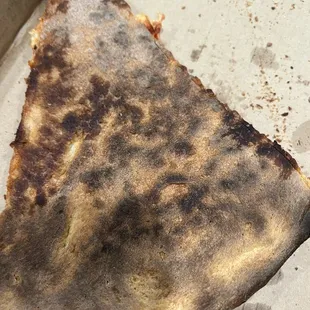 Burnt hard and cold pizza