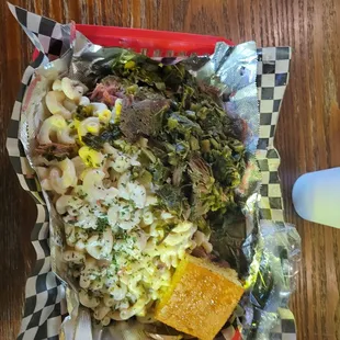 Greens mac &amp; cheese with cornbread all on top of a smoked turkey leg