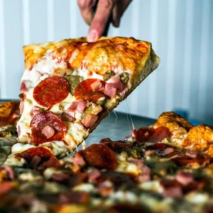 A cheesy slice of supreme pizza at Corolla Pizza &amp; Deli in Corolla, North Carolina.