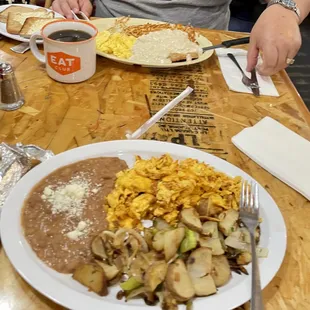 scrambled eggs with chorizo, refried beans and homemade potatoes. chicken fried steak with scrambled eggs and hash browns.