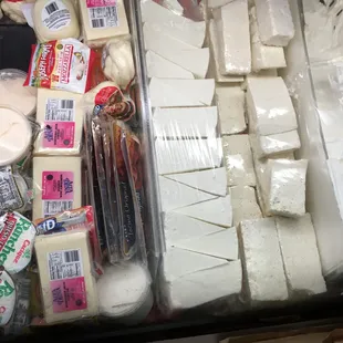 a variety of cheeses in a display case