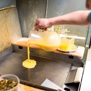 a person pouring something into a container