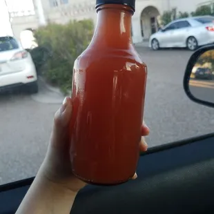 a hand holding a bottle of ketchup