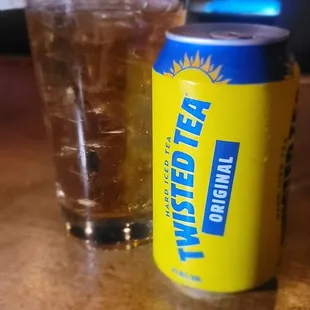 a can of lemonade next to a glass of lemonade