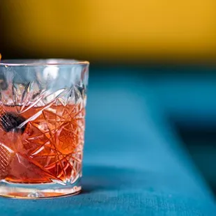 a drink in a glass on a blue table