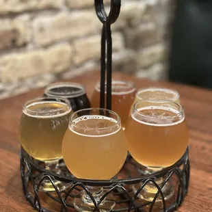 four glasses of beer in a basket