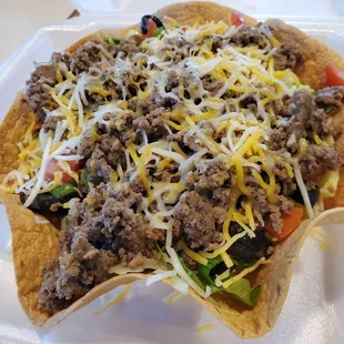 a taco salad in a styrofoam container