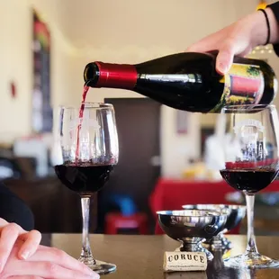 a person pouring a glass of wine